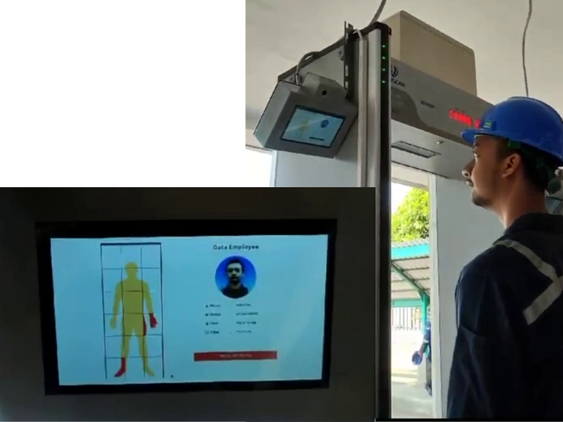 Workers are passing through a security gate with a face recognition system and metal scanner, the results of the metal detection location (if any) and identity data are also displayed on the monitor screen.